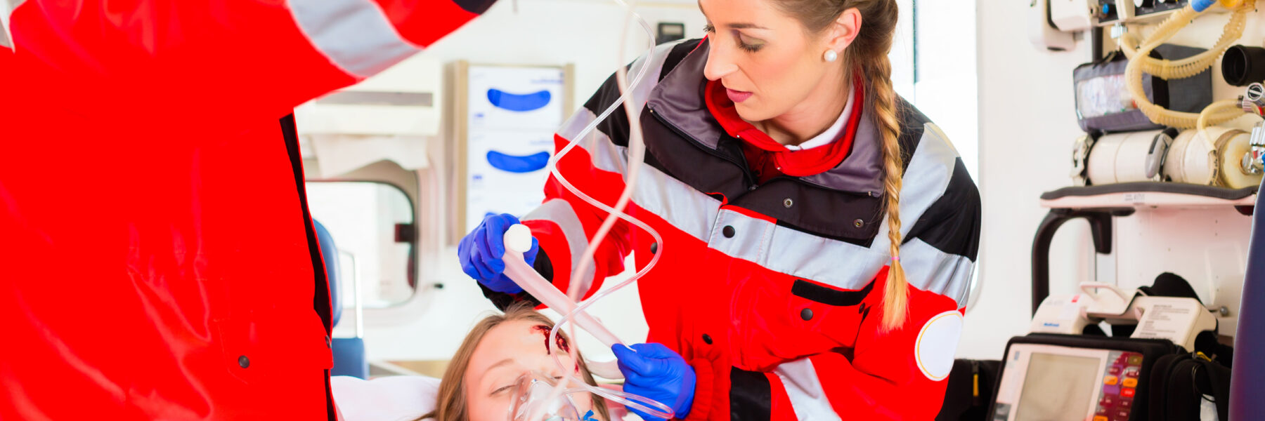 Notfallsanitäter Rettungssanitäter und Patient im Rettungswagen RTW Infusion Verband Beatmung